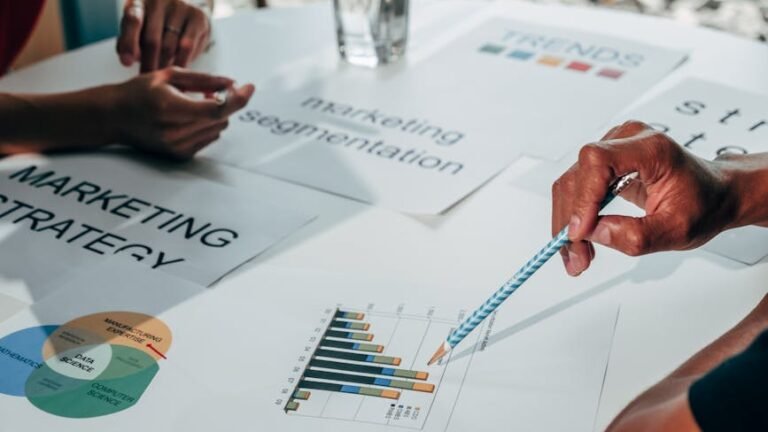 Team working on marketing strategy using data charts and papers in an office meeting.
